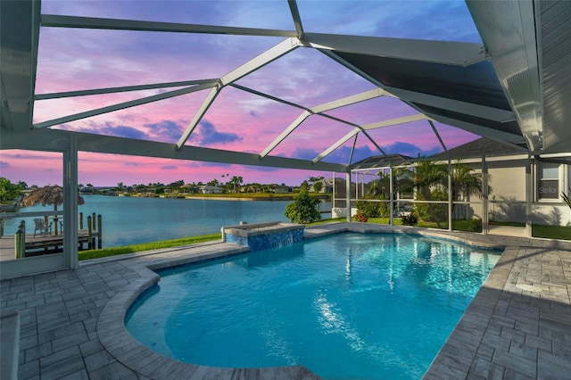 pool at dusk featuring a water view, a lanai, an outdoor pool, and a patio