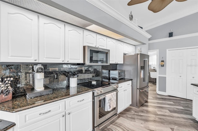 kitchen with tasteful backsplash, dark stone counters, stainless steel appliances, and crown molding