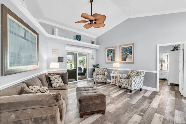 living area with crown molding, vaulted ceiling, baseboards, and wood finished floors