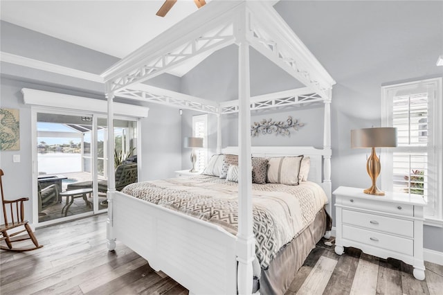 bedroom featuring access to exterior, ceiling fan, vaulted ceiling, and wood finished floors