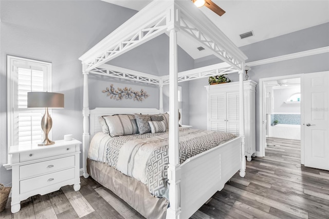 bedroom featuring lofted ceiling, wood finished floors, visible vents, baseboards, and a ceiling fan