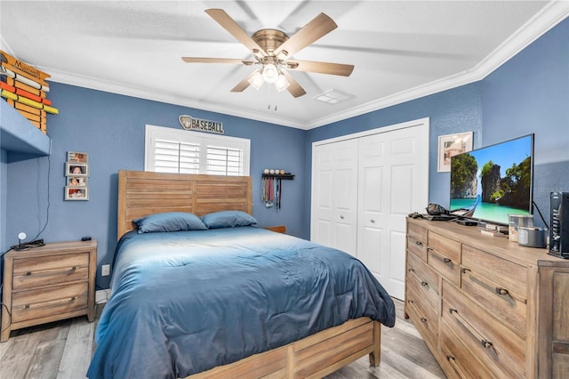 bedroom featuring light wood finished floors, ornamental molding, a closet, and a ceiling fan