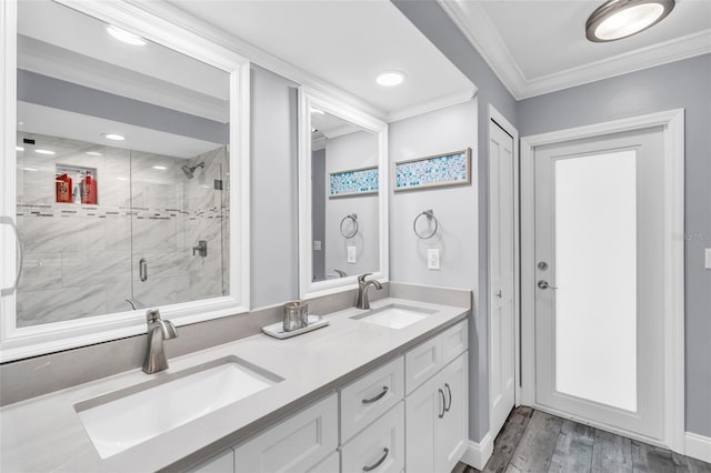 bathroom with crown molding, a sink, a shower stall, and wood finished floors