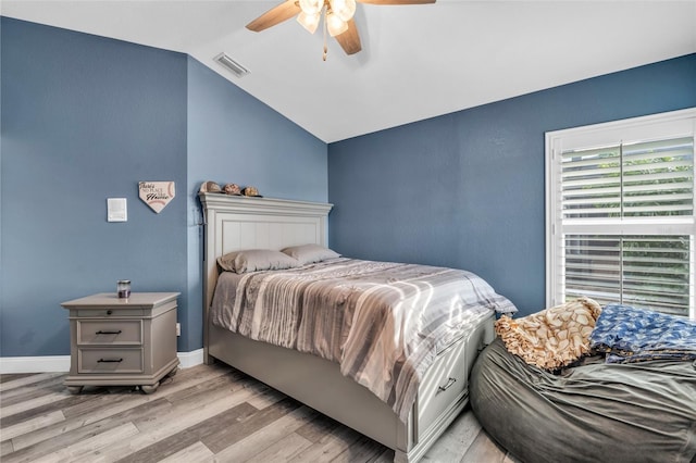 bedroom with a ceiling fan, visible vents, vaulted ceiling, baseboards, and light wood-type flooring