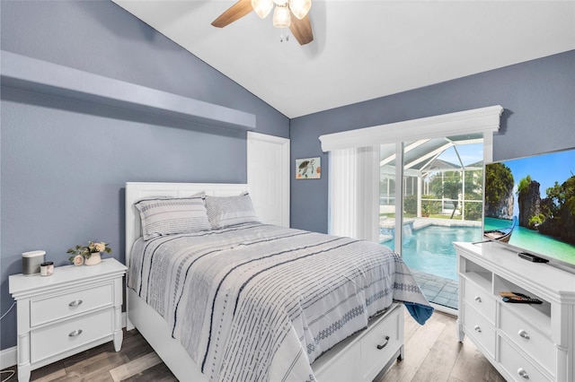 bedroom with lofted ceiling, wood finished floors, a sunroom, and access to exterior