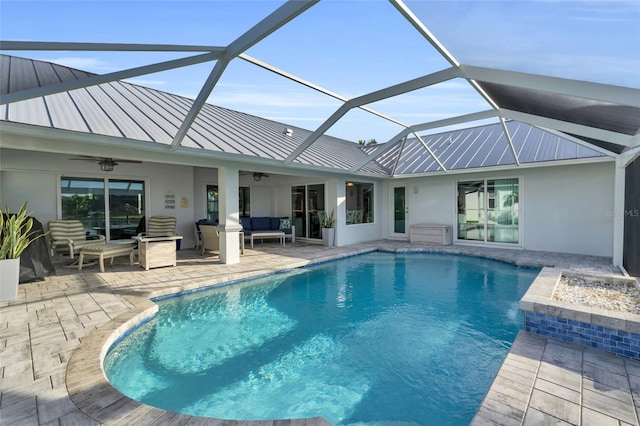 pool featuring an outdoor hangout area, ceiling fan, a patio area, and glass enclosure