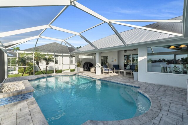 outdoor pool featuring a lanai, a ceiling fan, and a patio