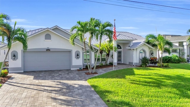 view of front of property with a front lawn, decorative driveway, an attached garage, and stucco siding