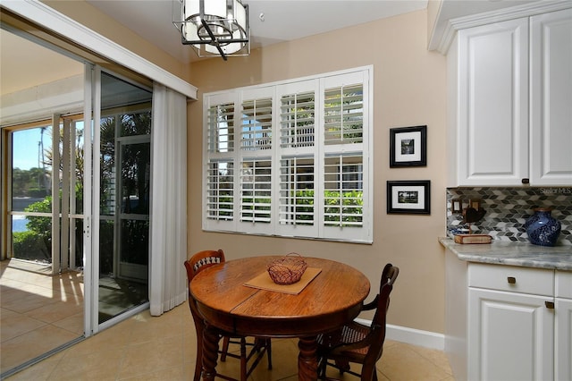 dining room featuring light tile patterned floors, an inviting chandelier, and baseboards