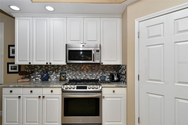 kitchen featuring tasteful backsplash, white cabinets, appliances with stainless steel finishes, light countertops, and recessed lighting