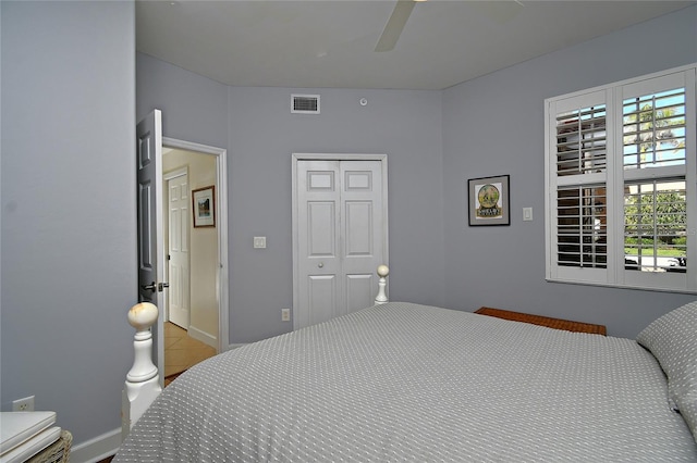 bedroom with visible vents, baseboards, a ceiling fan, a closet, and tile patterned floors