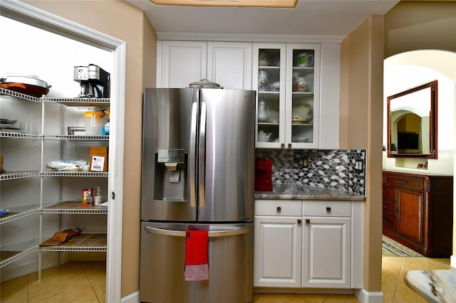 kitchen featuring light tile patterned floors, white cabinetry, backsplash, and stainless steel fridge with ice dispenser