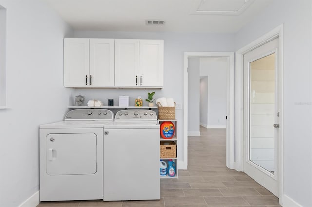 laundry room featuring wood finish floors, visible vents, baseboards, cabinet space, and washing machine and clothes dryer