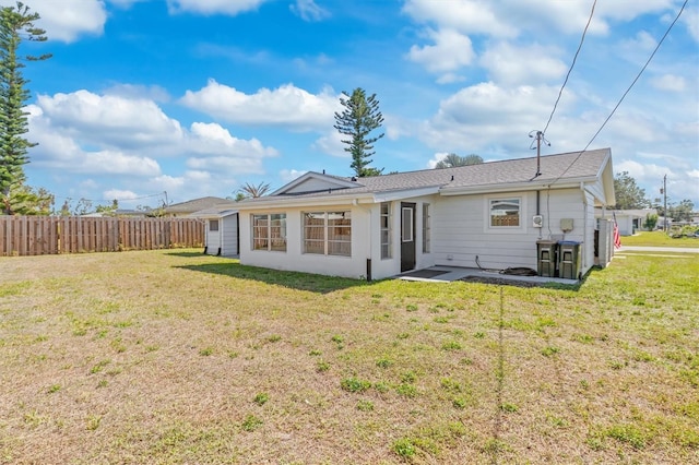 back of house with fence and a lawn