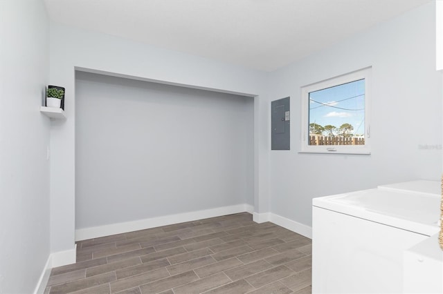 laundry room with laundry area, baseboards, electric panel, wood tiled floor, and washer and clothes dryer