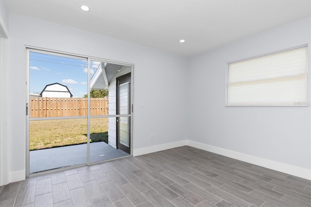 empty room with baseboards, wood finished floors, and recessed lighting