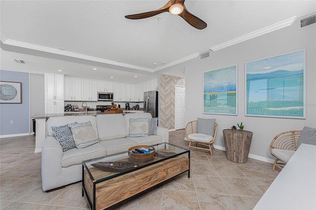 living area featuring baseboards, visible vents, and ornamental molding