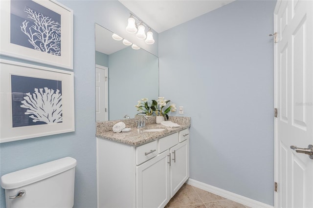 bathroom with tile patterned flooring, baseboards, vanity, and toilet