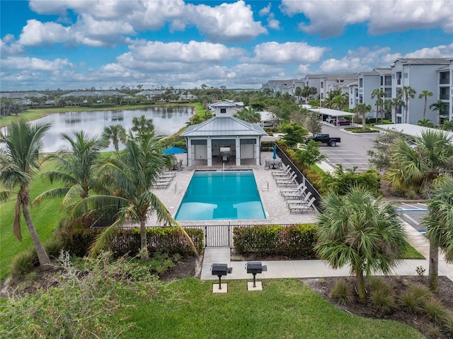 community pool featuring a yard, a water view, a gazebo, a patio area, and fence