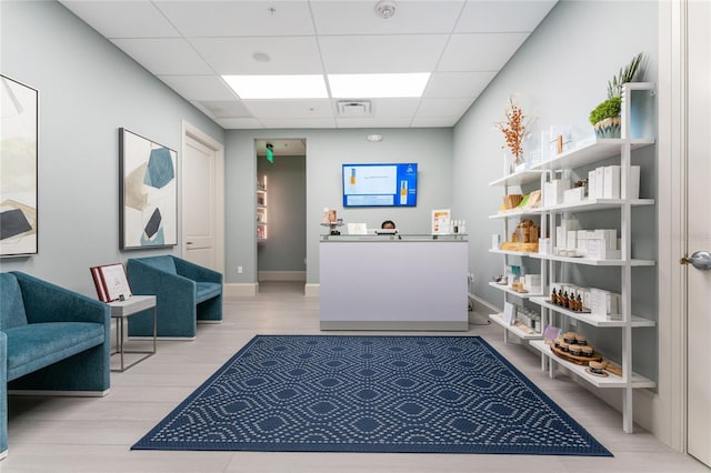 interior space featuring a drop ceiling, wood finished floors, visible vents, and baseboards