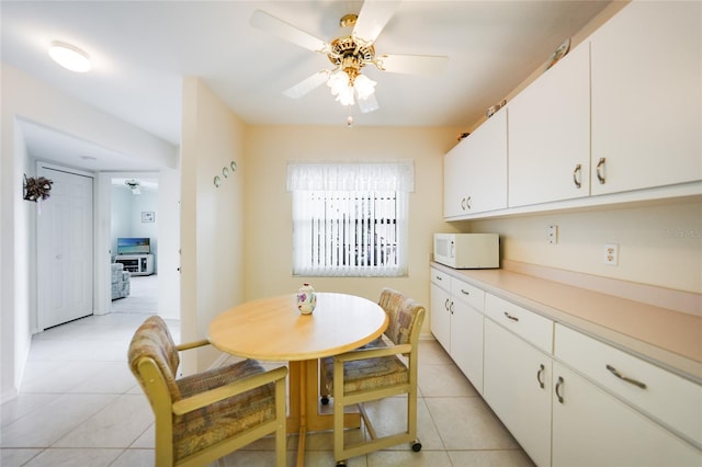 dining room with light tile patterned floors and a ceiling fan