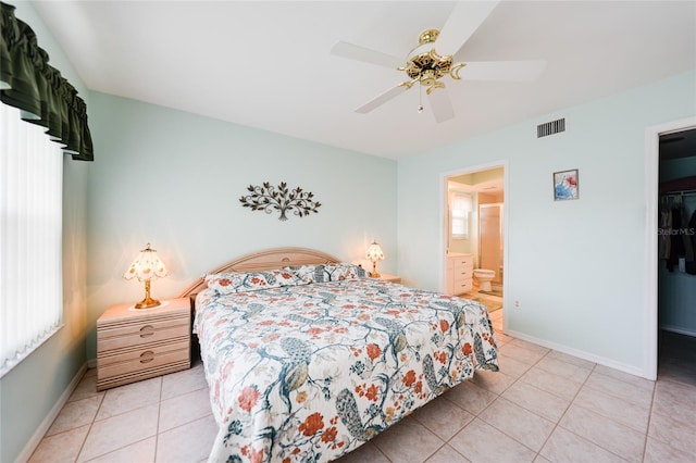 bedroom featuring light tile patterned floors, ensuite bathroom, visible vents, and baseboards