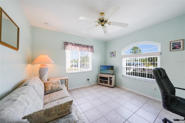 home office with a ceiling fan, baseboards, and tile patterned floors