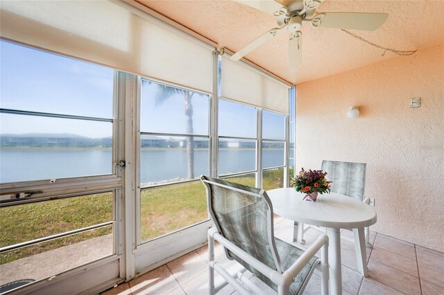 sunroom with a water view and a ceiling fan