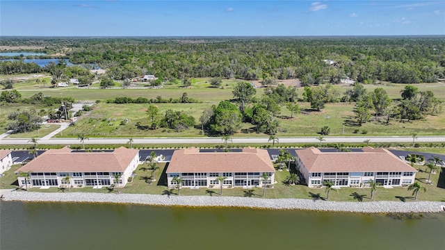 drone / aerial view with a forest view and a water view