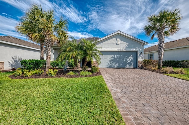 view of front facade featuring decorative driveway, an attached garage, a front yard, and stucco siding