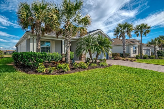 view of front of home with a front yard, decorative driveway, and stucco siding