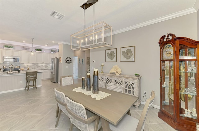 dining room featuring light tile patterned floors, baseboards, visible vents, and crown molding