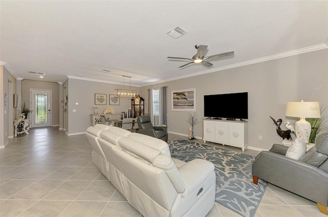 living room with crown molding, light tile patterned floors, visible vents, baseboards, and ceiling fan with notable chandelier