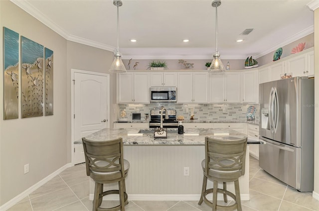 kitchen with visible vents, decorative backsplash, appliances with stainless steel finishes, a breakfast bar, and white cabinetry