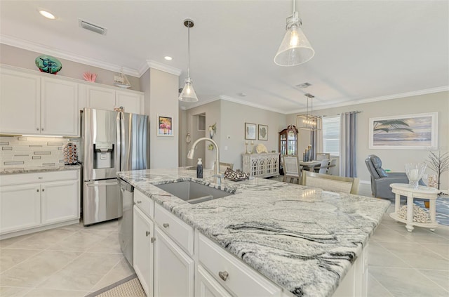 kitchen with appliances with stainless steel finishes, a sink, visible vents, and crown molding