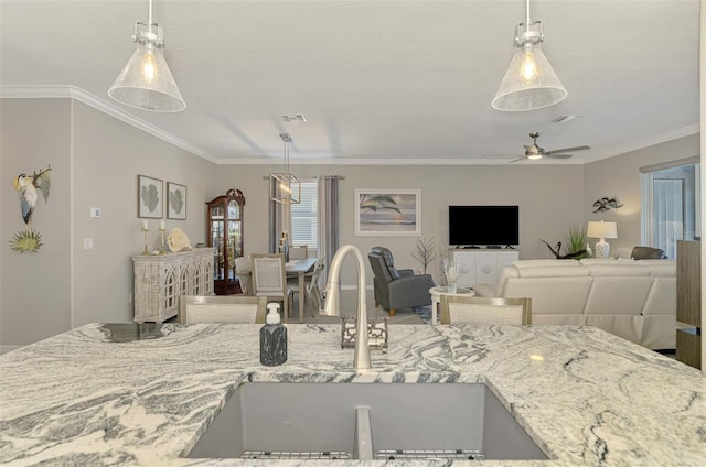 kitchen featuring ornamental molding, visible vents, a sink, and light stone counters