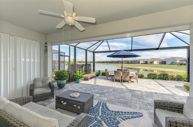 view of patio / terrace with glass enclosure, outdoor dining area, outdoor lounge area, a water view, and a ceiling fan