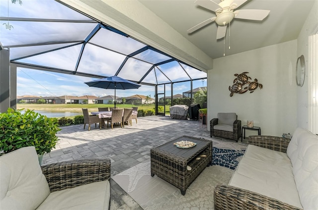 view of patio featuring a water view, an outdoor hangout area, outdoor dining space, ceiling fan, and a lanai