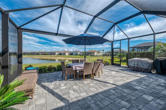 view of patio / terrace featuring a lanai, a water view, outdoor dining area, and area for grilling