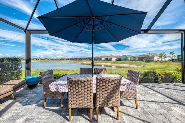 view of patio with a lanai, a water view, and outdoor dining area