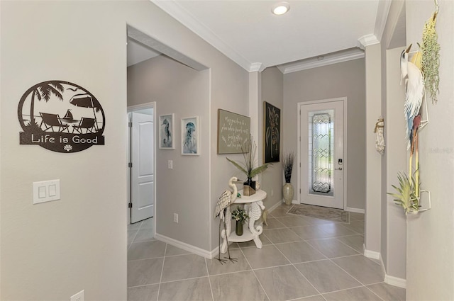 foyer with baseboards, tile patterned floors, and crown molding