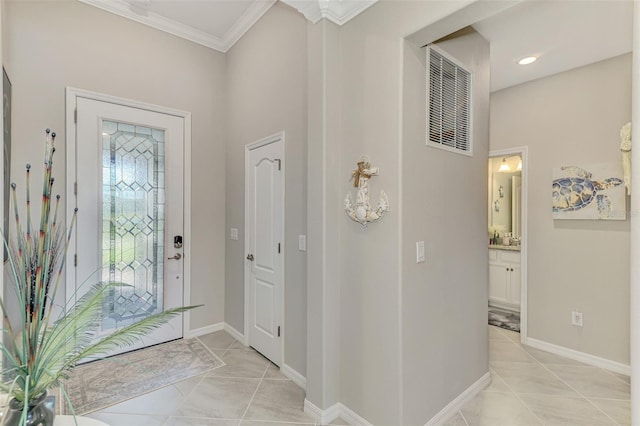 entryway with ornamental molding, light tile patterned flooring, visible vents, and baseboards