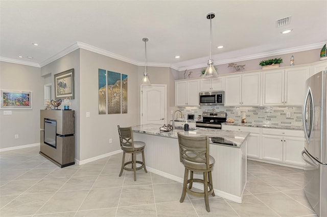 kitchen with appliances with stainless steel finishes, visible vents, white cabinets, and backsplash