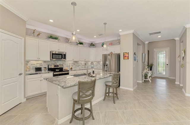 kitchen with stainless steel appliances, a sink, white cabinetry, decorative backsplash, and crown molding