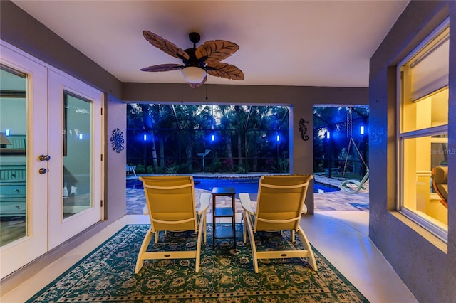 sunroom / solarium with a ceiling fan and french doors