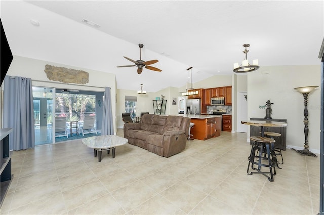 living area with light tile patterned floors, baseboards, visible vents, lofted ceiling, and ceiling fan with notable chandelier