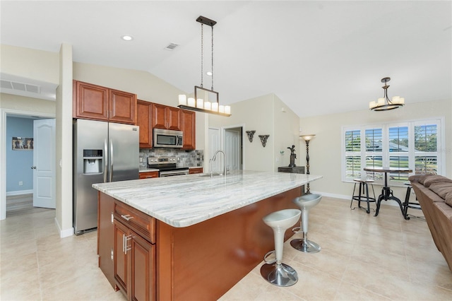 kitchen with decorative light fixtures, stainless steel appliances, lofted ceiling, backsplash, and a sink