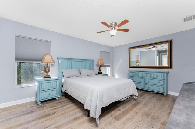 bedroom featuring ceiling fan, light wood-type flooring, visible vents, and baseboards