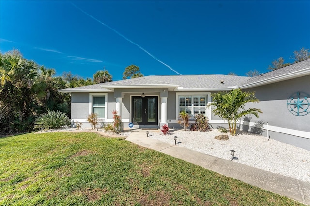 view of front of property featuring french doors, a front lawn, and stucco siding