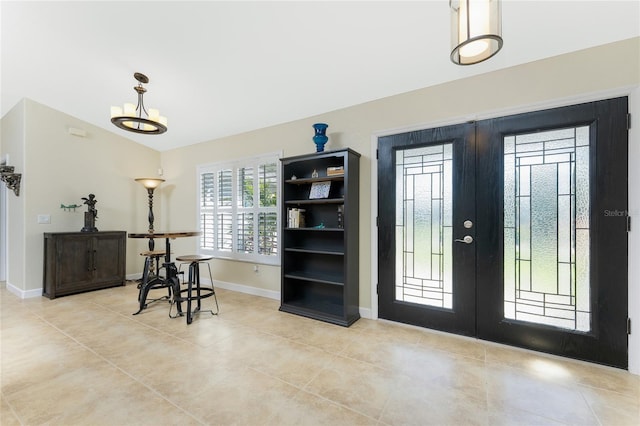 entryway with lofted ceiling, french doors, baseboards, and light tile patterned floors